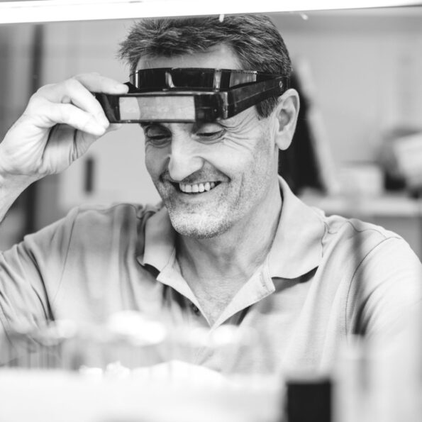 Zahntechniker im Eigenlabor mit Schutzbrille
